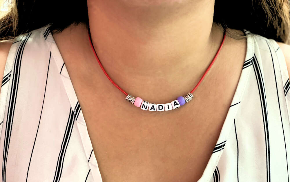Woman wearing necklace with name Nadia